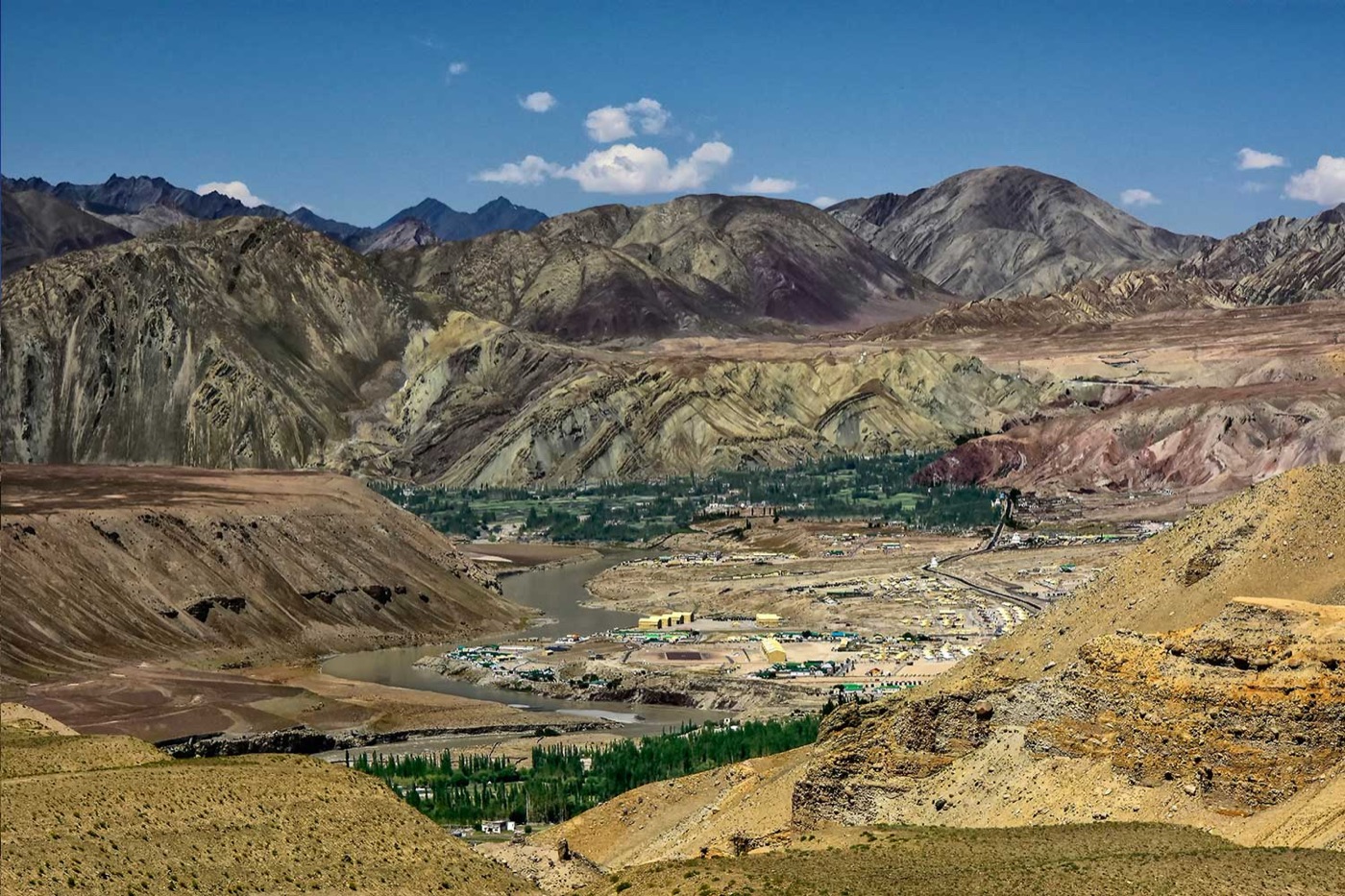 The town of Leh spread across a river basin, seen from the surrounding ridges